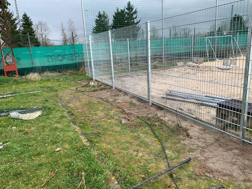 Ballfangzaun während der Montage an einem Sportplatz