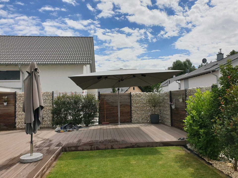 Garten mit Holzdeck, Sichtschutzelementen und Gabionenwand