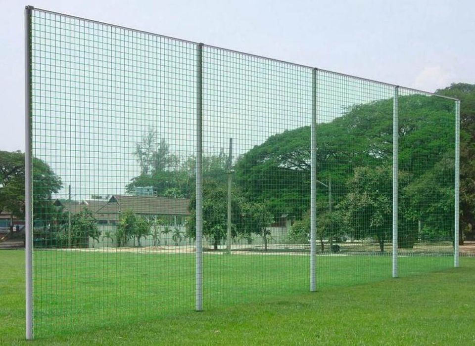 Hoher Ballfangzaun aus Gittermatten an einem Sportplatz